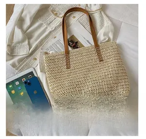 Detail view of straw tote bag showing large capacity for iPad and phone