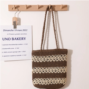 Handwoven straw tote bag with brown and cream stripes and hollow out pattern for beach travel