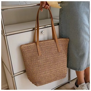 Detail of handwoven straw tote bag showing fine crochet texture and brown leather handle
