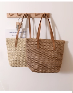 Detail of straw woven tote bags with leather handles in beige and natural brown colors