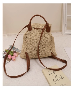 Close-up of woven straw backpack with adjustable leather straps and drawstring closure