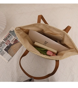 Interior view of large straw tote bag showing spacious storage with inner pocket