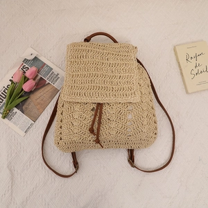 Beige crochet straw backpack with brown leather straps and镂空 wavy patterns for beach