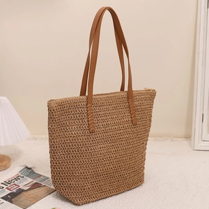 Minimalist straw tote bag with brown faux leather straps for summer beach or daily use