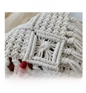 Detailed close-up of intricate hand-woven cotton patterns on a boho straw crossbody bag
