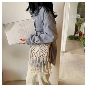 Detail of handmade macramé crossbody bag featuring geometric patterns and long tassels