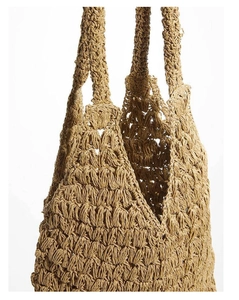 Dettaglio della borsa a tracolla in paglia con motivo intrecciato a mano e texture