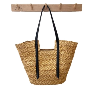 Grand sac cabas en paille tressée avec anses en cuir noir pour la plage en été