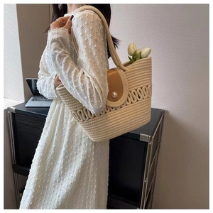 Detail van hol geweven katoenen tas met leren klep en elegante parelmoer knoopsluiting