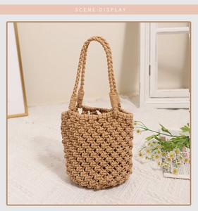 Close-up of the handcrafted khaki woven bucket bag on a soft textured surface