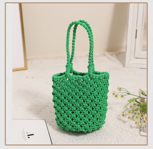 Close-up of green hand-woven cotton macrame handbag showing intricate hollow mesh texture