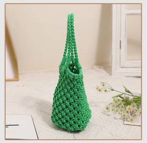 Detail of green handmade woven cotton rope handbag with hollow geometric mesh texture