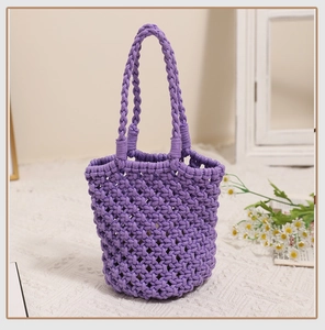 Close-up of a purple woven bucket bag with detailed hollow mesh knitting and rope handles