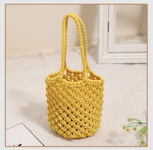 Detail view of yellow woven cotton rope bucket bag with hollow diamond mesh pattern
