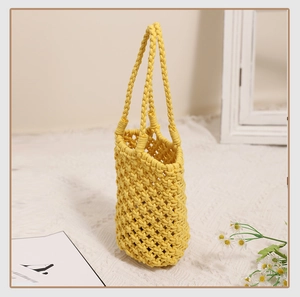 Detail of yellow cotton woven handbag showing intricate crochet mesh and dual handles
