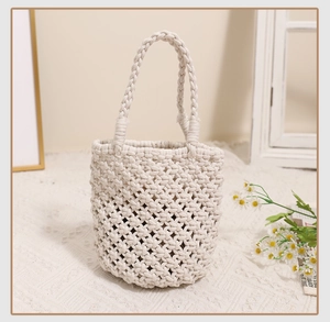 Detailed view of the woven cotton rope texture and grid pattern on the cream tote bag