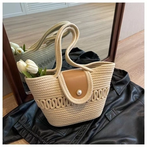 Detail van de katoenen strandtas met bruine lederen flap en een parelsluiting