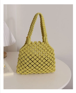 Detail of green woven cotton rope tote bag with intricate hollow mesh pattern for summer