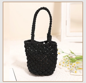 Close-up of black handmade woven crochet tote bag with hollow diamond mesh texture