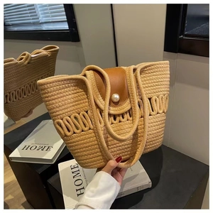 Detail van beige geweven katoenen tas met bruine leren klep en parelknoopsluiting
