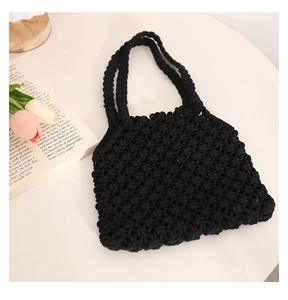Close-up of black handmade woven tote bag featuring thick rope mesh texture and boho style