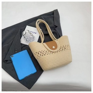Detail van beige geweven textuur met bruine leren flap en decoratieve parelknoop
