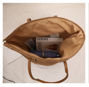 Close-up of the spacious interior lining and straw weave texture of the tote bag