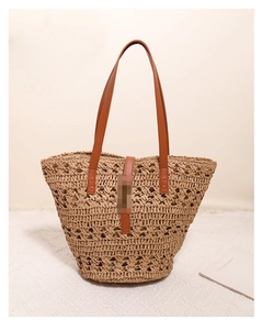 Detailed macro view of woven straw beach bag with brown leather strap and texture