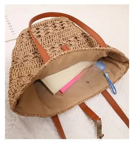 Top view of large straw tote bag showing spacious interior with books and umbrella