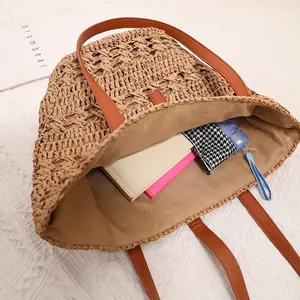 Hollow out straw tote bag with brown leather handles and large capacity interior
