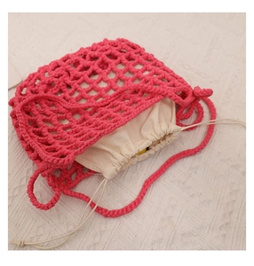 Detail showing fuchsia crochet mesh shoulder bag with a beige drawstring inner pouch