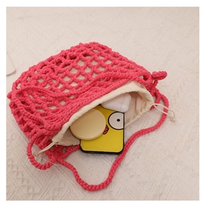 Detail of rose pink crochet beach bag showing off-white drawstring liner and daily storage space