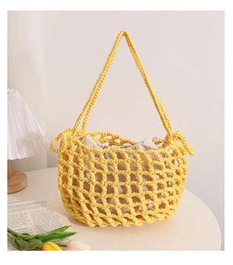 Detail of yellow hollow knit mesh tote bag with beige drawstring inner pouch on table