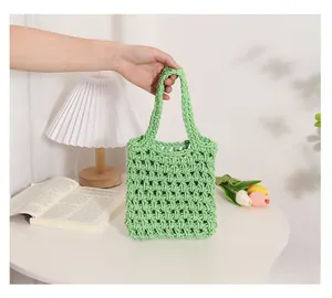 Detail of green handmade woven tote bag with hollow mesh design and soft rope handle