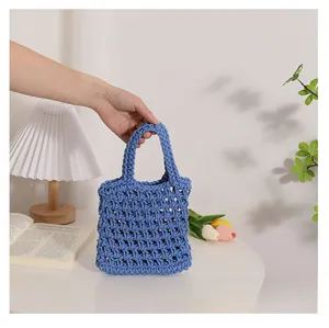 Detail view of a blue hand-woven cotton rope bag showing hollow texture and double handles