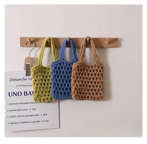 Detail of three handmade crochet woven handbags in green, blue, and khaki brown cotton rope