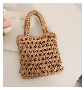 Detail of hand-woven cotton rope handbag with hollow mesh design in khaki color