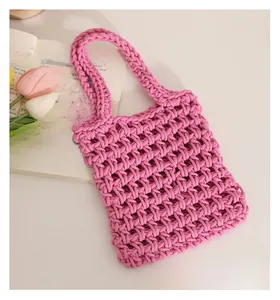 Close-up of pink hand-woven cotton rope bag featuring hollow mesh pattern and sturdy handle