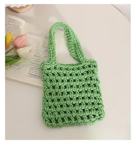 Detail of green hand-woven cotton rope bag with hollow diamond pattern mesh texture