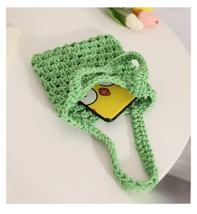 Detail view of the green woven cotton hand bag with intricate hollow texture and handle