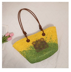 Detail of hand-woven straw tote with yellow-green gradient and brown leather straps