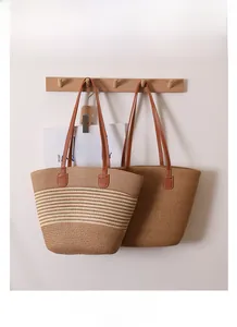 Close-up of woven straw tote bags in solid brown and striped designs with leather straps
