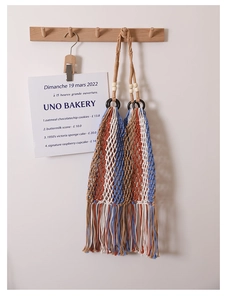 Detail of bohemian woven bag featuring blue and orange stripes with tassel fringe