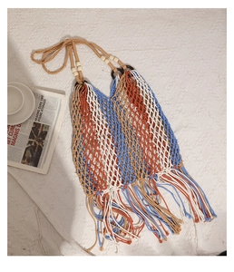 Detail of bohemian hand-woven cotton bag with colorful tassels and wooden beads