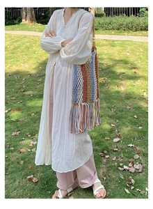 Detail of colorful woven shoulder bag featuring long tassels and bohemian fringe elements