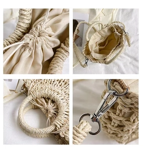 Detail of straw bag features woven handles, drawstring lining and metal D-rings