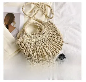 Detail view of woven semi-circle handbag with hollow grid design and inner drawstring pouch