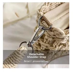 Detail view of woven straw bag with detachable shoulder strap and silver metal clasps