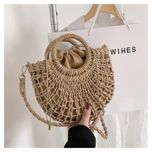 Detail of semicircular straw handbag showing hollow weave pattern and drawstring pouch