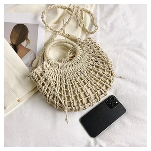 Close-up of a woven straw beach bag featuring hollow mesh texture and drawstring pouch